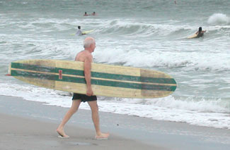 old timer surfer with longbord at sunset beach, Florida
